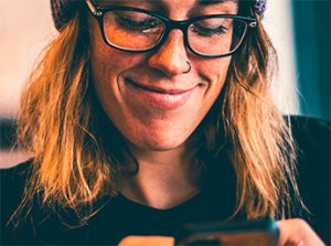 hipster girl on phone smiles at her phone